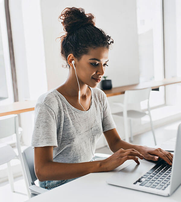 Giovane donna al laptop in un ufficio luminoso