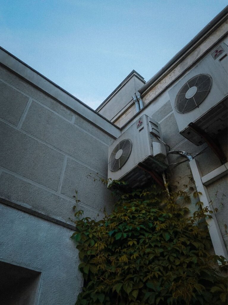 Due unità esterne di climatizzazione installate sulla parete di un cortile
